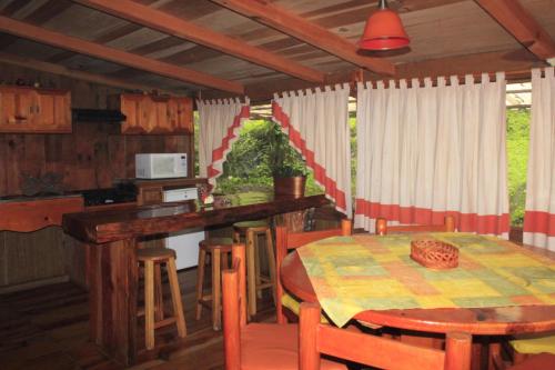 a kitchen and dining room with a table and chairs at Cabañas Alpinas López Fontes in Valle de Bravo
