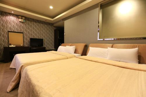 two beds in a hotel room with a large screen at Wanli Spa & Resort in Wanli
