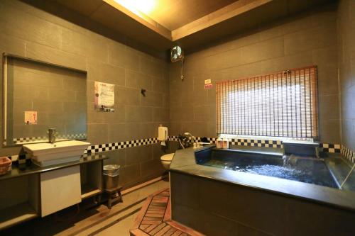 萬里的住宿－萬里仙境溫泉會館 ，带浴缸和盥洗盆的大浴室