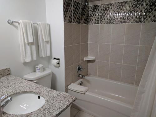 uma casa de banho com um lavatório, um WC e um chuveiro em Franklin Motel, Tent & Trailer Park em North Bay