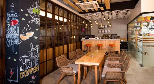 a dining room with a wooden table and chairs at Ayaartta Hotel Malioboro in Yogyakarta