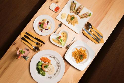 a wooden table with plates of food on it at Ayaartta Hotel Malioboro in Yogyakarta