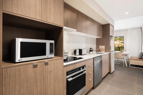 a kitchen with a microwave, oven, dishwasher and refrigerator at Quest Eight Mile Plains in Brisbane