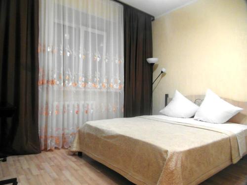 トムスクにあるКварт отель Надежда Московский тракт 6/3のベッドルーム1室(ベッド1台、大きな窓付)