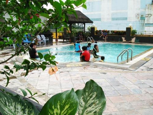 un grupo de personas sentadas en una piscina en Good Hope Hotel, en Skudai