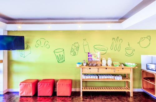 a room with a green wall with drawings on the wall at ibis Budget - Campbelltown in Campbelltown