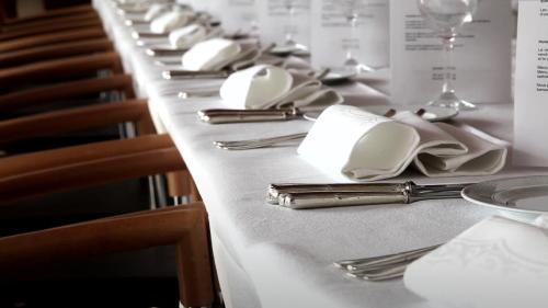 a long table with white napkins and silverware at Hôtel 17.4 - Lycée d'Hôtellerie et de Tourisme in Blois