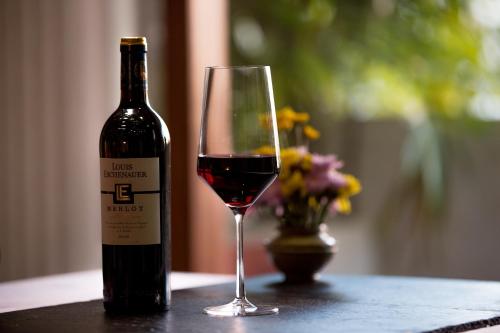 a bottle of red wine sitting next to a glass at Golden Temple Boutique in Siem Reap