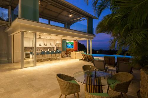 an outdoor patio with a glass table and chairs at Anjali Casa Divina in Sayulita