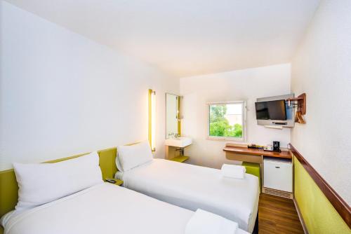 a hotel room with two beds and a television at ibis Budget - St Peters in Sydney