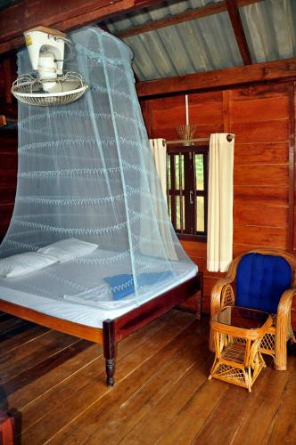 a bed with a net on it in a room at Happy Elephant Bungalows in Koh Rong Island