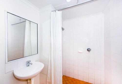 Baño blanco con lavabo y espejo en ibis Budget - Dubbo, en Dubbo