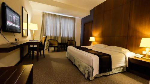 a hotel room with a large bed and a television at Times Hotel Brunei in Bandar Seri Begawan