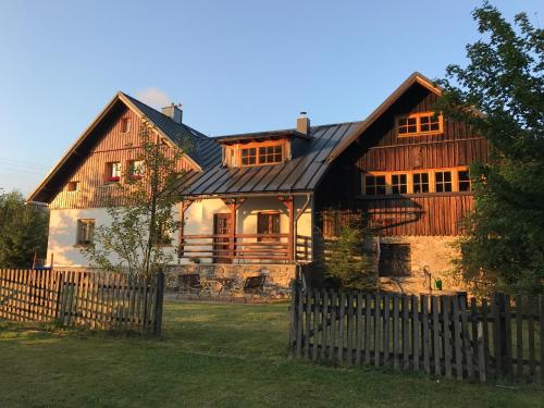 a large wooden house with a black roof at Ubytování na Slučím Tahu in Prášily