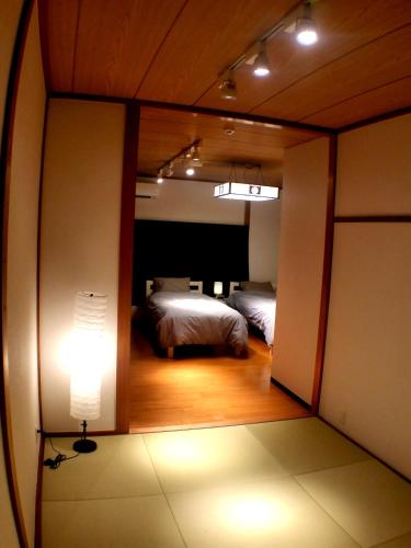 a view of a bedroom with a bed and a lamp at Tsudoh Stay Hikoso in Kanazawa