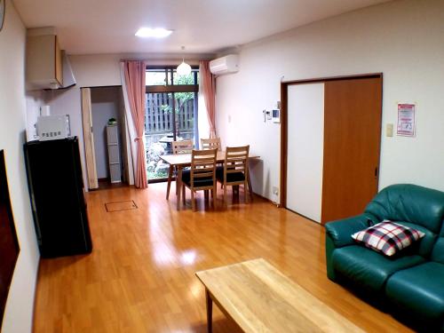 sala de estar con sofá y mesa en Tsudoh Stay Hikoso, en Kanazawa