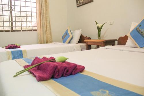 a hotel room with two beds with towels on them at Tropical Breeze in Siem Reap