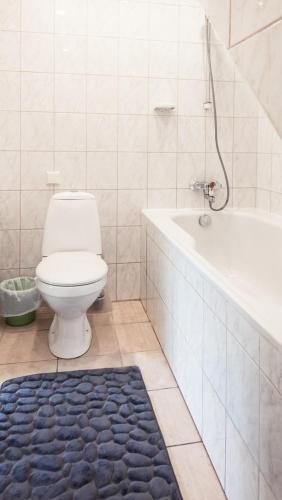 a bathroom with a toilet and a tub and a rug at Best Stay-Pärnu Villa in Pärnu