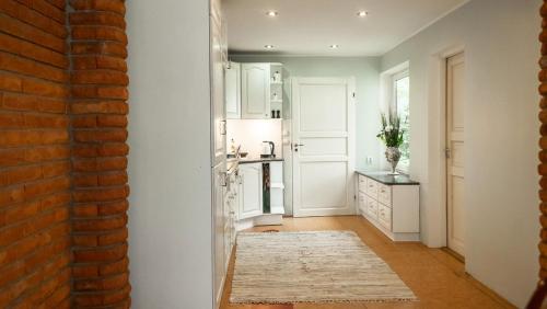una cocina con armarios blancos y una pared de ladrillo rojo en Best Stay-Pärnu Villa, en Pärnu