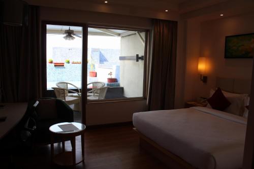 a hotel room with a bed and a table and a window at Pearltree Hotels And Resorts in Purulia