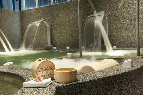 礁溪鄉的住宿－福岡5號溫泉會館，浴室配有喷泉和浴缸及水槽
