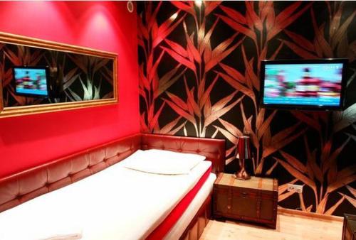 a red room with a bed and a mirror at Zajazd U Dudziarza in Kościan
