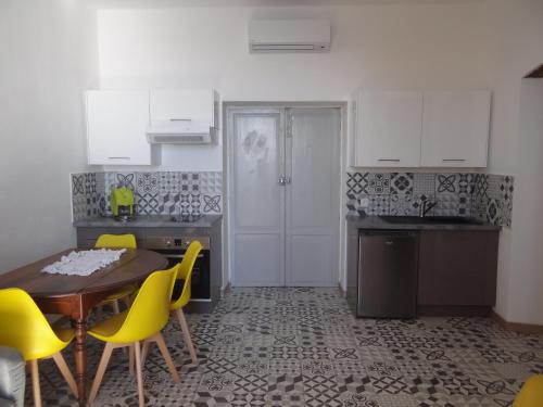 Una cocina con una mesa de madera y sillas amarillas. en Appartement Colonella, en Bastia