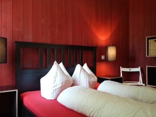 Klein StrömkendorfにあるRotes Strandhaus mit Boot am Salzhaff, 50m zum Strandのベッドルーム1室(赤い壁と白い枕のベッド2台付)