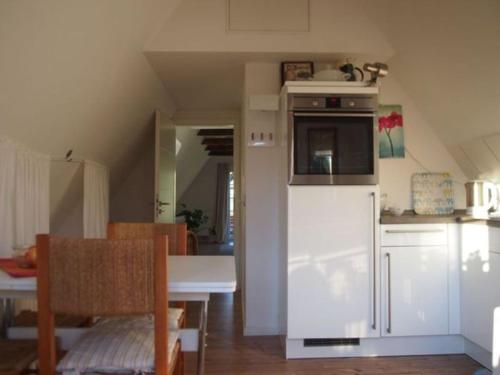 una cucina con un frigorifero bianco e un tavolo di Reetdach - Promenadenblick - 500m zum Strand a Prerow