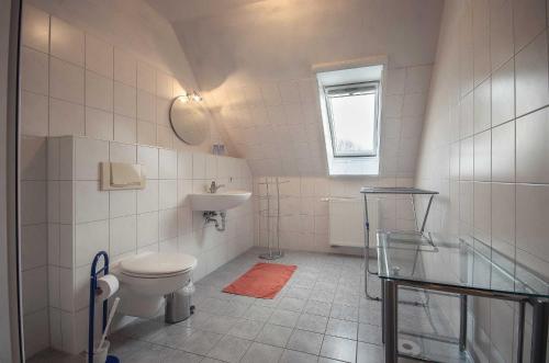 a white bathroom with a toilet and a sink at Pferdehof Ranzow in Ranzow
