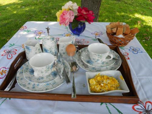 a table with plates and cups and a tray of food at Il Casale Del Sogno in Ardea