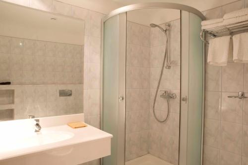 a bathroom with a shower and a sink at Hotel Maxim in Oradea