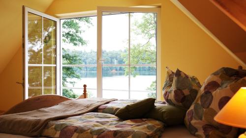 a bedroom with a bed in front of a large window at Haus am Pinnower See in Pinnow