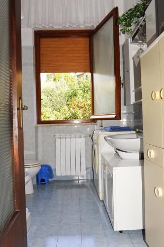a bathroom with a sink and a toilet and a window at casa di erika in Varazze