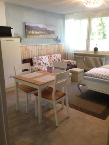 sala de estar con mesa, sillas y sofá en Ferienwohnung mit Charme I, en Todtmoos