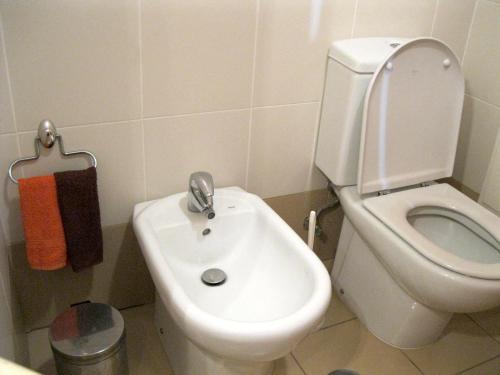 Un baño con un inodoro blanco y un lavabo. en Estacada Apartment, en Machico