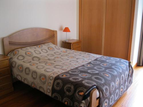 Un dormitorio con una cama, una cómoda y una lámpara. en Estacada Apartment, en Machico