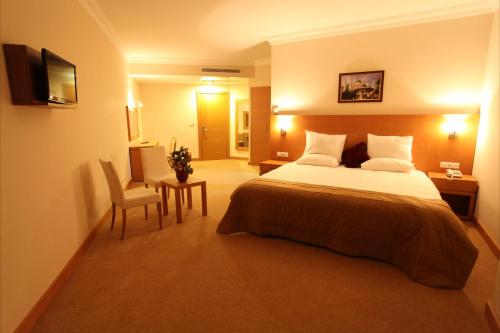 1 dormitorio con cama, escritorio y silla en Shilla Hotel en Velimeşe