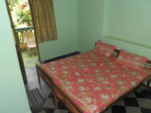 a small room with a bed with a red blanket at Babush Ocean Star in Palolem