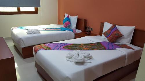 ein Schlafzimmer mit 2 Betten und Handtüchern darauf in der Unterkunft The Supara in Bangkok
