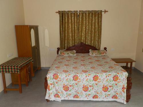 a bedroom with a bed with a floral bedspread at Babush Ocean Star in Palolem