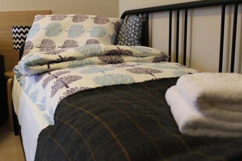 a bed with a blanket and pillows on it at 3-Studio in Poznań