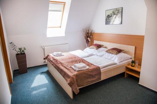 1 dormitorio con 1 cama grande con sábanas blancas en Hotel Eminent, en Zlaté Moravce