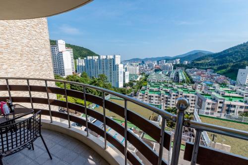 a balcony with a view of a city at Home Fourest Resort Geoje in Geoje 