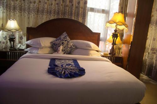 a bedroom with a large bed with blue and white pillows at Zimbo Golden Hotel in Dar es Salaam