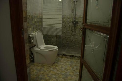 a bathroom with a toilet and a shower at Zimbo Golden Hotel in Dar es Salaam