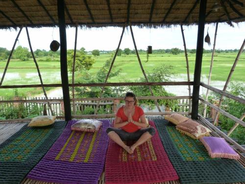 a woman sitting on a mat on a tent at Battambang Dream Bungalows in Battambang