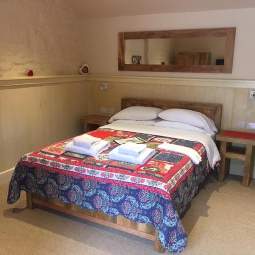 a bedroom with a bed with a quilt on it at Widbrook Barns in Bradford on Avon