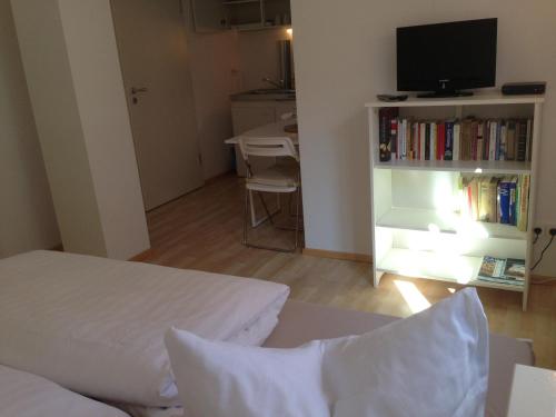 a bedroom with a bed and a tv and a table at Petite Bellevue II in Baden-Baden