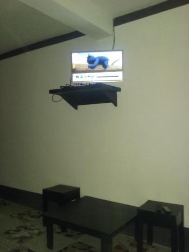 a tv on a wall in a room with a table at Villa Cassis in Ivato